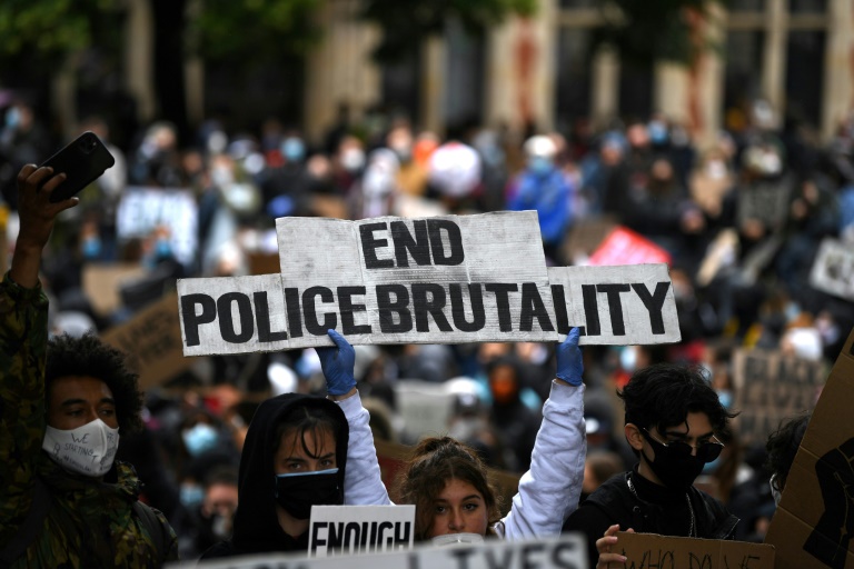 "Mettons fin à la brutalité policière", clame une pancarte au milieu de la manifestation qui s'est tenue devant le Parlement à Londres, le 6 juin 2020